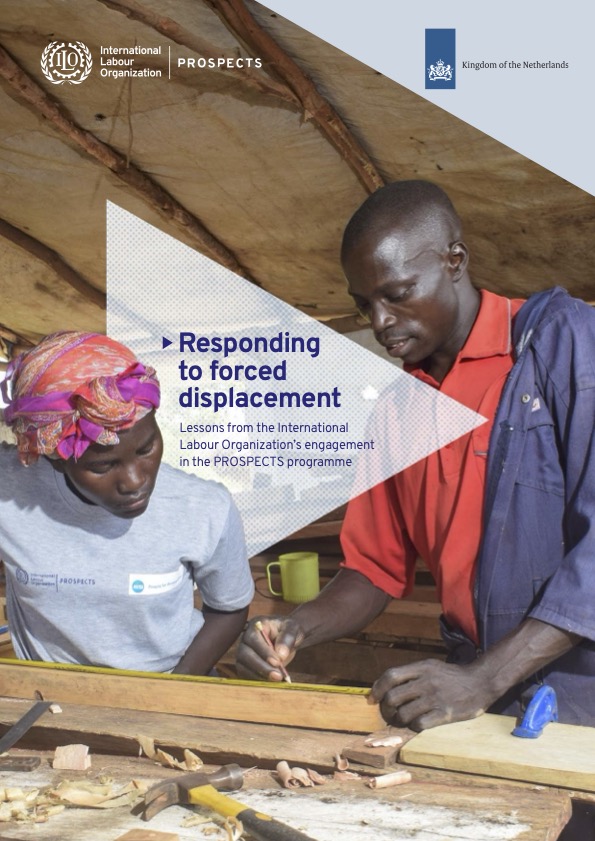 Image of one worker showing another worker how to measure and mark on a piece of wood on a workshop table