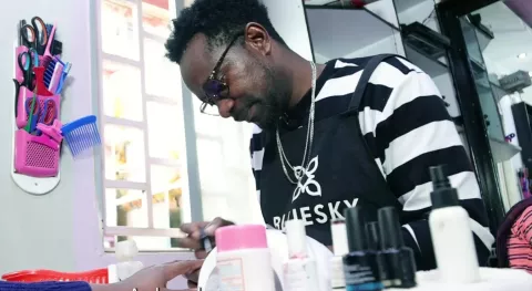 Image of a worker in a beauty salon paining nails of a customer