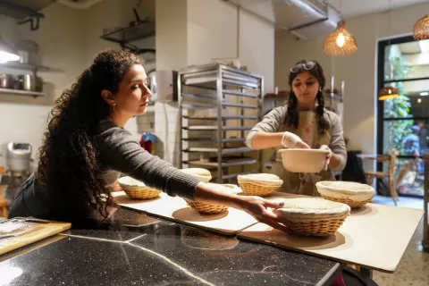 Image of two ladies making bread in a bakery