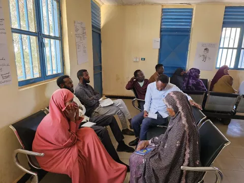 Image of a group of people sitting in a waiting room in a community centre