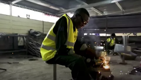 Image of a trainee working in a workshop welding some tools with protective glasses on